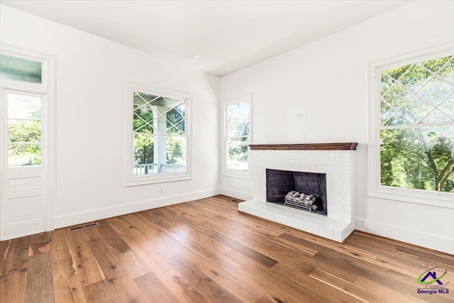 unfurnished living room with hardwood / wood-style flooring and a fireplace