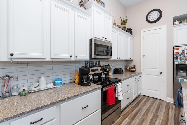 kitchen with stainless steel appliances, light stone countertops, tasteful backsplash, dark wood-type flooring, and white cabinets