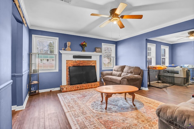 living room with a fireplace, ceiling fan, dark wood-type flooring, and crown molding