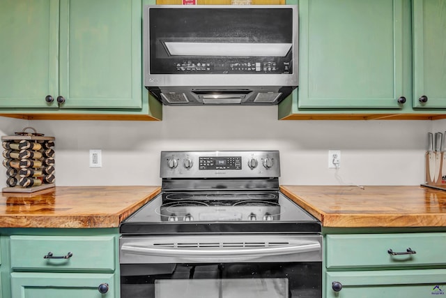 kitchen with butcher block countertops, stainless steel appliances, and green cabinets