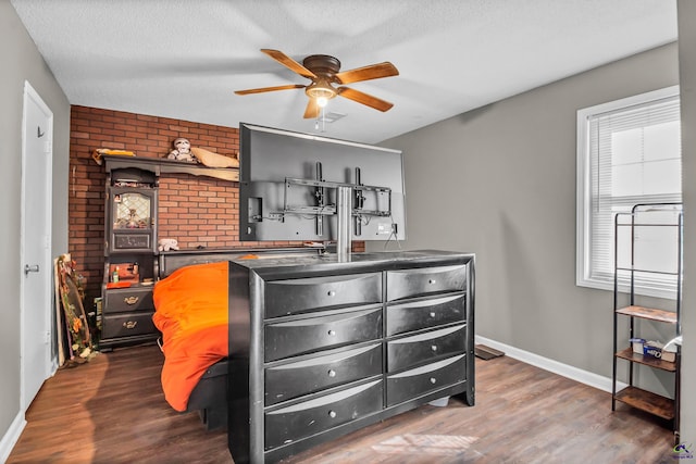 bedroom featuring ceiling fan, dark hardwood / wood-style flooring, and a textured ceiling