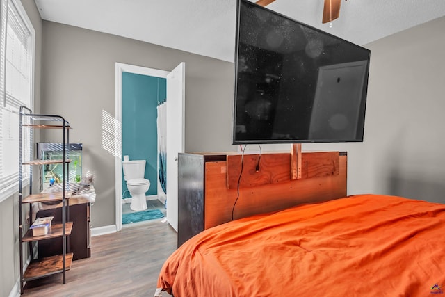 bedroom featuring hardwood / wood-style flooring and ensuite bath