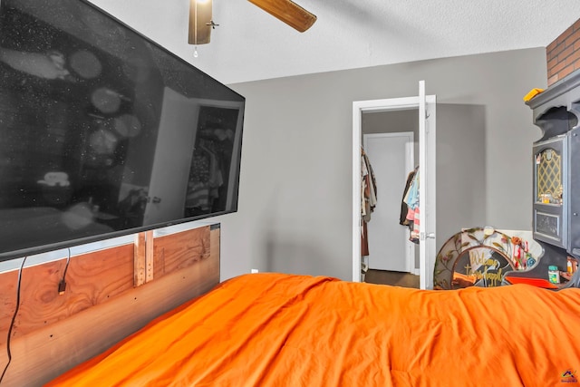 bedroom with ceiling fan and a textured ceiling