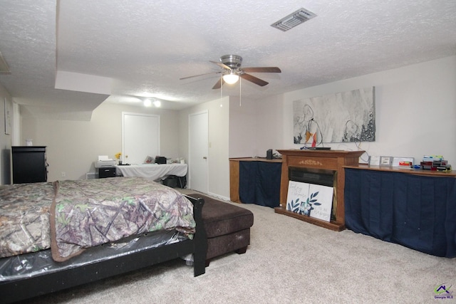 bedroom featuring carpet, ceiling fan, and a textured ceiling