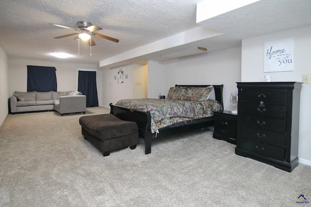 carpeted bedroom featuring ceiling fan and a textured ceiling