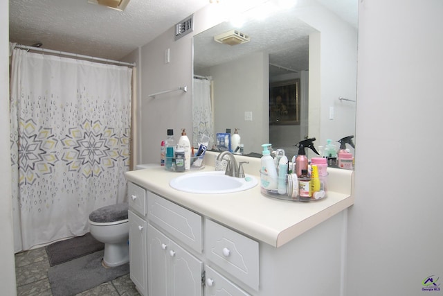 bathroom with toilet, vanity, and a textured ceiling