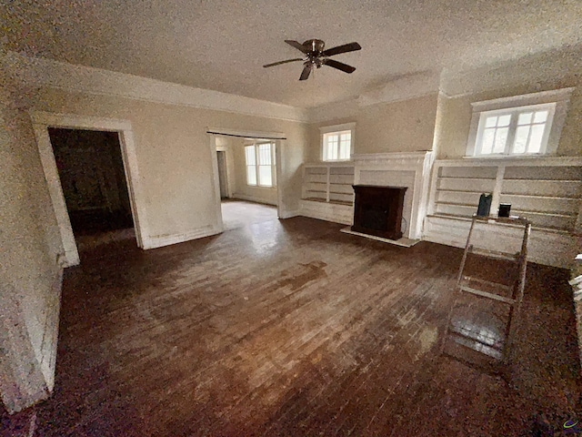 unfurnished living room with ceiling fan, dark hardwood / wood-style flooring, and a textured ceiling