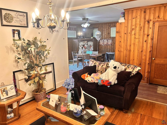 living room featuring hardwood / wood-style floors and ceiling fan with notable chandelier