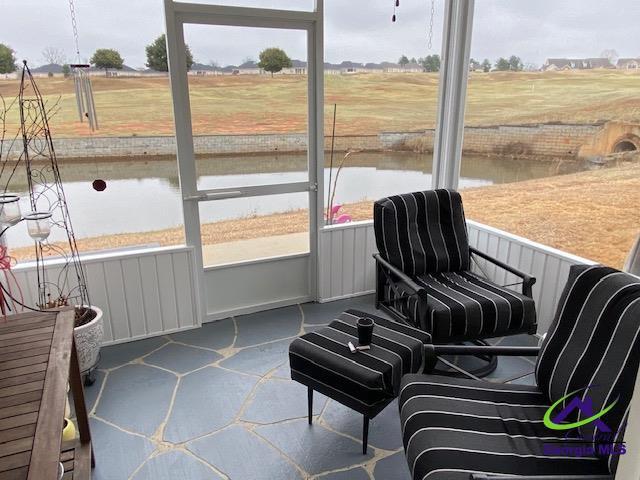 sunroom / solarium with a water view and a healthy amount of sunlight