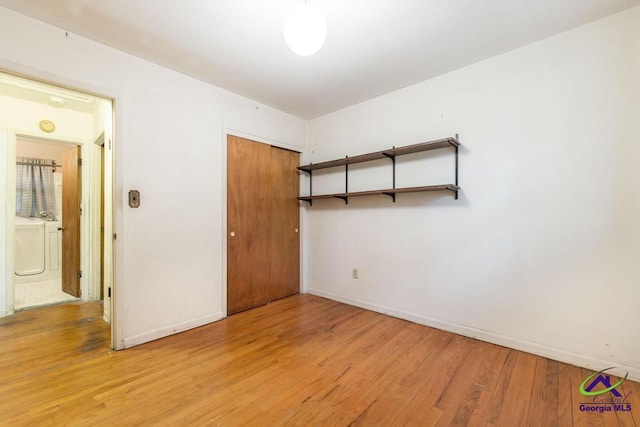 empty room with light wood-type flooring and washer / dryer