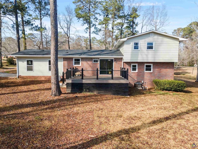 back of house featuring a lawn, a deck, and central AC