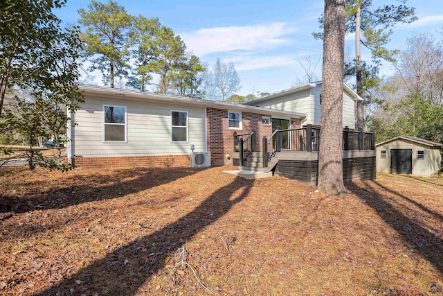 rear view of house featuring a deck, ac unit, and a storage unit