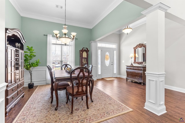 dining room with ornamental molding, plenty of natural light, dark wood-type flooring, and ornate columns