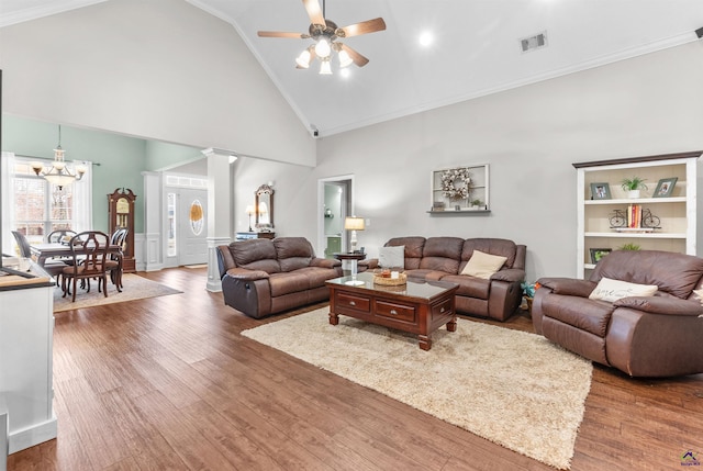 living room with dark hardwood / wood-style floors, crown molding, ceiling fan, high vaulted ceiling, and ornate columns