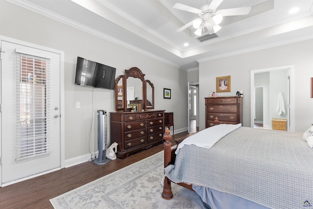 bedroom featuring ceiling fan, dark wood-type flooring, crown molding, and a raised ceiling