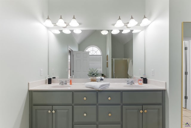 bathroom with tile patterned flooring, vanity, a shower with door, and lofted ceiling