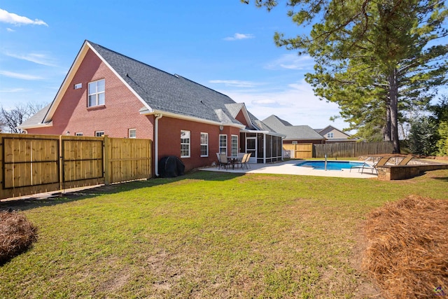 rear view of property featuring a sunroom, a lawn, a fenced in pool, and a patio area