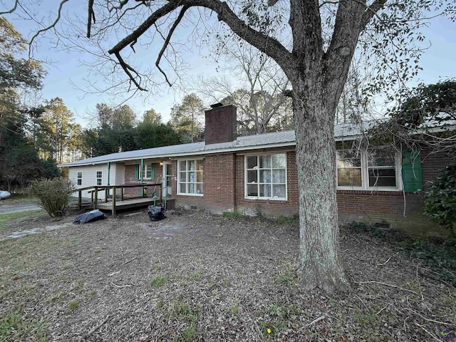 single story home with crawl space, brick siding, a chimney, and a wooden deck