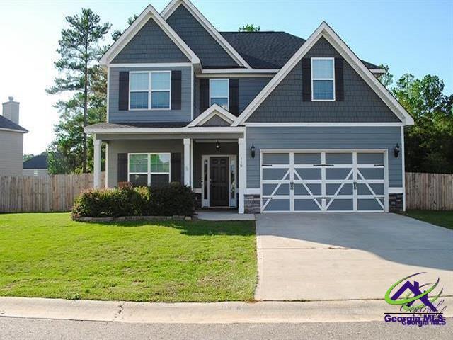 craftsman house featuring a garage, fence, concrete driveway, and a front yard