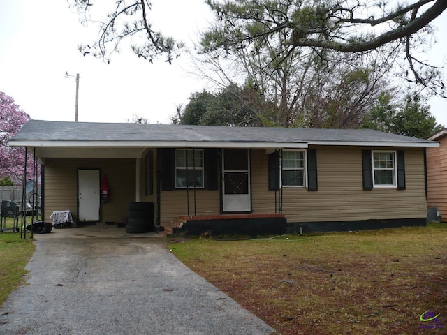 single story home featuring aphalt driveway, an attached carport, and a front lawn