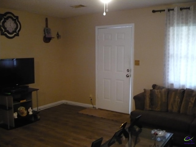 living room with visible vents, baseboards, and wood finished floors