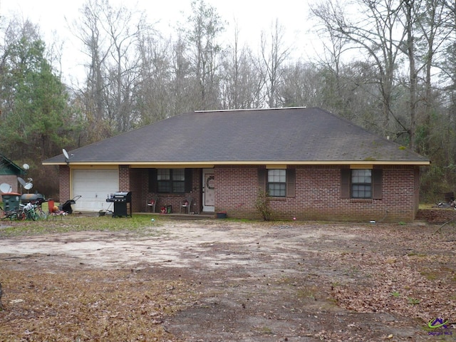 ranch-style house featuring brick siding, driveway, and an attached garage