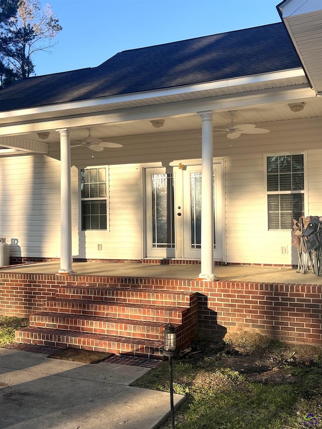 view of side of property featuring covered porch, brick siding, a ceiling fan, and roof with shingles