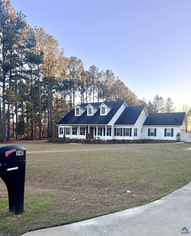 cape cod-style house with a porch and a front lawn