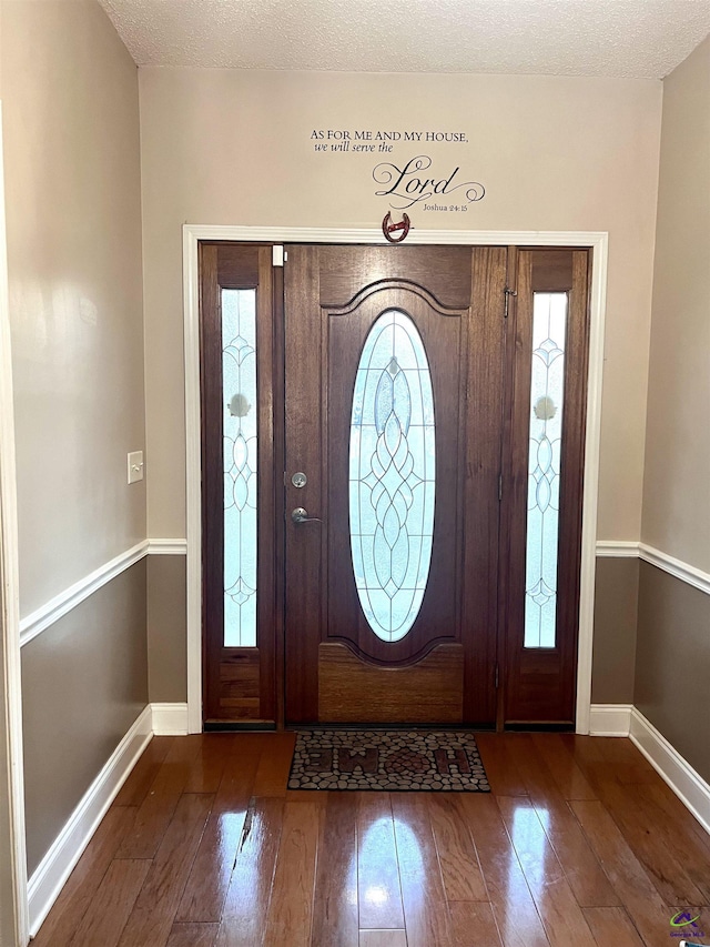 entrance foyer featuring a textured ceiling, wood finished floors, and baseboards