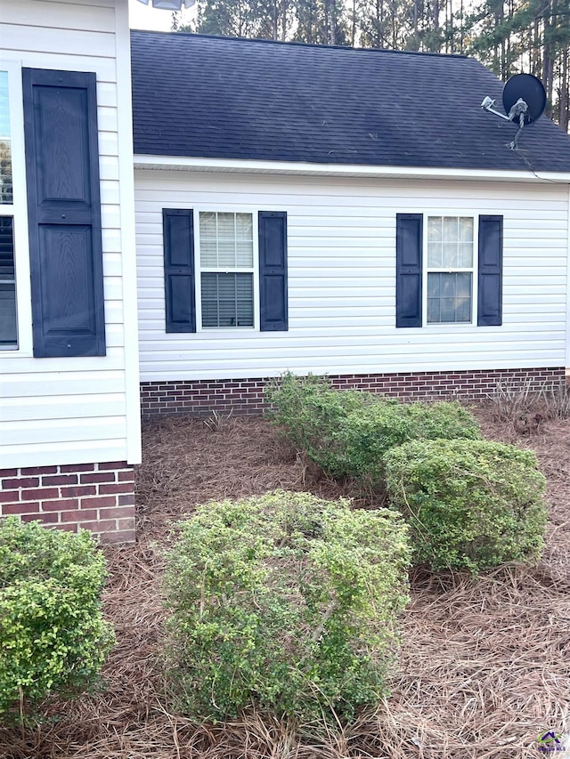 view of home's exterior with roof with shingles