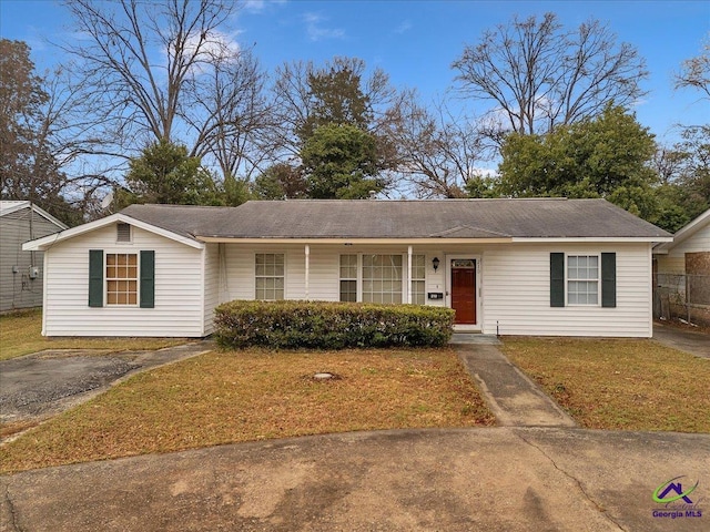 ranch-style house featuring driveway and a front lawn