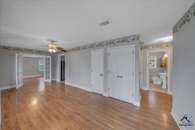 interior space with french doors, visible vents, light wood-style flooring, and baseboards