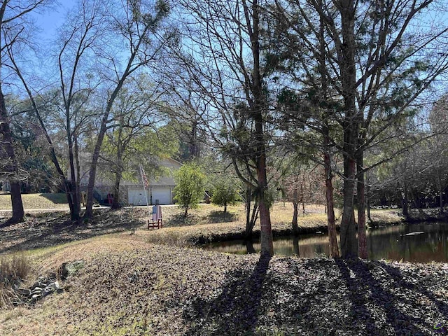 view of yard with a garage and a water view