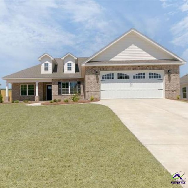 view of front of house with driveway, a garage, a front yard, and brick siding