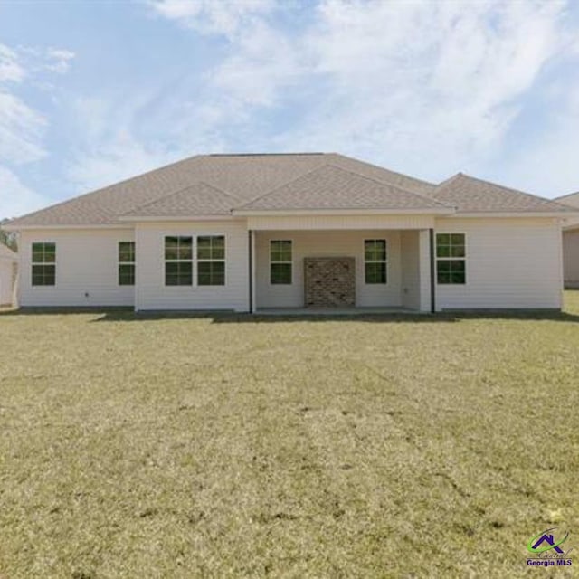 rear view of property featuring a yard