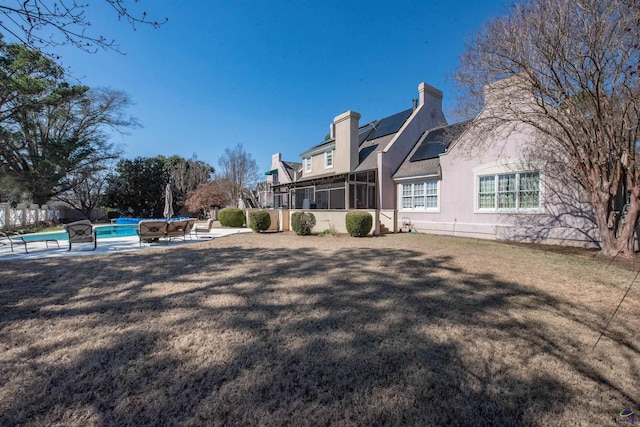 view of yard with a patio area, a sunroom, and an outdoor pool