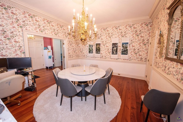 dining area with dark wood-style floors, a wainscoted wall, crown molding, and wallpapered walls