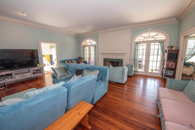 living room with dark wood-style floors, french doors, ornamental molding, and a premium fireplace