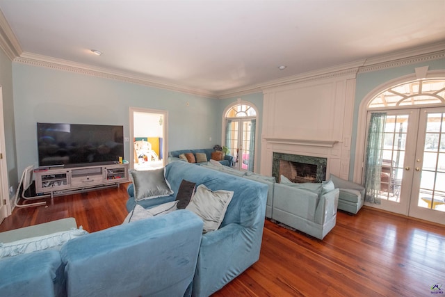 living room featuring a high end fireplace, ornamental molding, dark wood-type flooring, and french doors