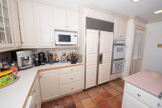 kitchen with glass insert cabinets, white cabinets, light countertops, and built in appliances