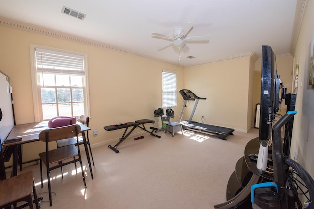 exercise room featuring ceiling fan, light colored carpet, visible vents, baseboards, and ornamental molding