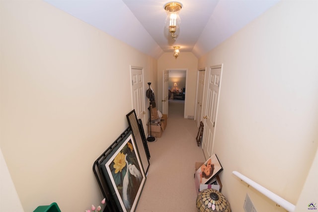 hall featuring carpet and vaulted ceiling