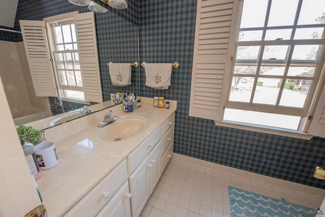 bathroom with baseboards, tile patterned flooring, vanity, and wallpapered walls