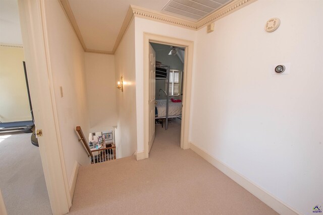 hall with carpet, crown molding, visible vents, an upstairs landing, and baseboards