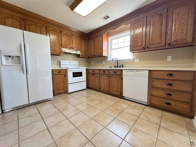 kitchen featuring visible vents, light countertops, brown cabinetry, white appliances, and under cabinet range hood