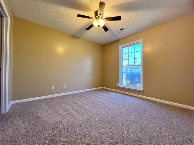 carpeted spare room with a textured ceiling, ceiling fan, visible vents, and baseboards