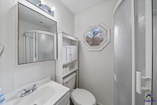 bathroom with toilet, a shower stall, and vanity