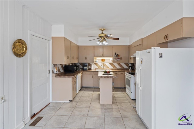 kitchen featuring a center island, dark countertops, backsplash, ceiling fan, and white appliances