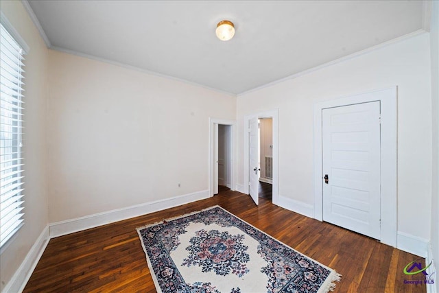 bedroom featuring baseboards, dark wood-style flooring, and crown molding