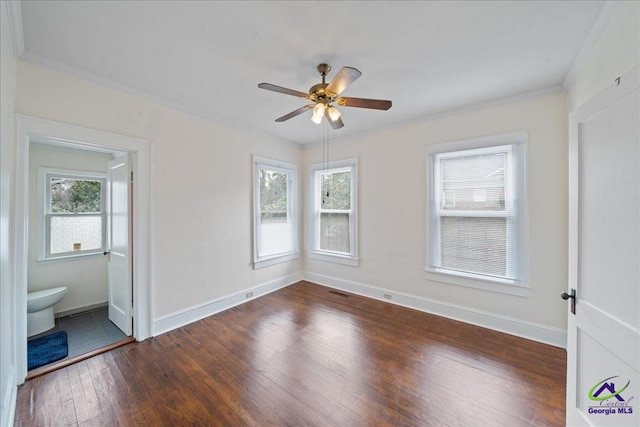 unfurnished bedroom with multiple windows, ornamental molding, dark wood-style flooring, and baseboards